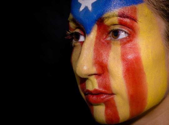 Vrouw met Catalaanse vlag op gezicht geschilderd